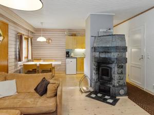 a living room with a couch and a fireplace at Holiday Home Kulta-käkönen 3 by bomba by Interhome in Nurmes