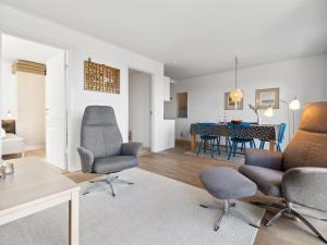 a living room with chairs and a dining room at Apartment Caisa - 75m from the sea in Bornholm by Interhome in Allinge