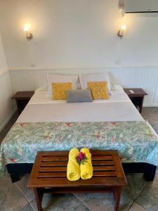 ein Schlafzimmer mit einem Bett mit gelben Schuhen auf einem Tisch in der Unterkunft Saint Leu - Gîte Ylang Ylang - Bardzour in Saint-Leu
