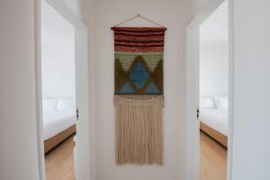 a room with white walls and a door with a rug at Raminhos Guest House in Vila Nova de Milfontes