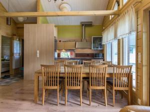 a dining room with a wooden table and chairs at Holiday Home Himosaurinko by Interhome in Jämsä