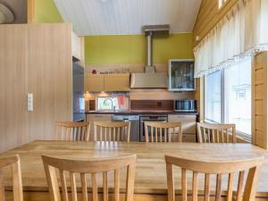a kitchen with a large wooden table and chairs at Holiday Home Himosaurinko by Interhome in Jämsä
