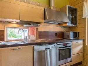 a kitchen with a stainless steel stove and a sink at Holiday Home Himosaurinko by Interhome in Jämsä +15 photos