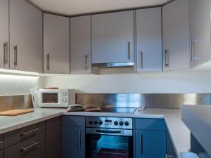 a kitchen with a blue oven and white cabinets at Chalet Sneachta by Interhome in Nendaz