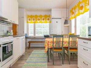 a kitchen with a table with chairs and a dining room at Holiday Home Halkoniemi by Interhome in Jämsä