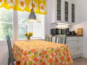 eine Küche mit einem Tisch und Stühlen mit einem gelben Vorhang in der Unterkunft Holiday Home Halkoniemi by Interhome in Jämsä
