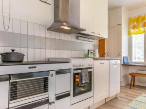 a kitchen with white appliances and a stove top oven at Holiday Home Halkoniemi by Interhome in Jämsä