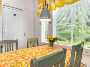 Holiday Home Halkoniemi by Interhome في يامسا: طاولة غرفة الطعام مع إناء من الزهور عليها