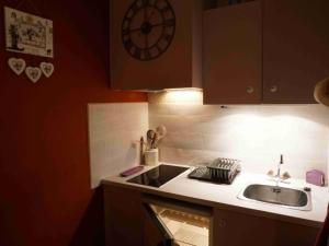 eine Küche mit einem Waschbecken und einer Uhr an der Wand in der Unterkunft Studio Pra-Loup, 1 pièce, 4 personnes - FR-1-165A-14 in Uvernet