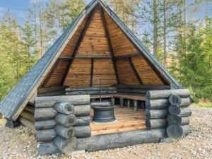 a large wooden house with a bucket in it at Holiday Home Vaaranpää by Interhome in Meltaus