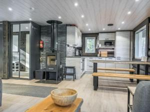 a living room with a kitchen with a stove at Holiday Home Vaaranpää by Interhome in Meltaus +22 photos