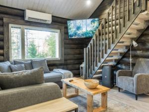 a living room with a couch and a staircase at Holiday Home Vaaranpää by Interhome in Meltaus