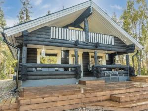 a log cabin with a porch and a deck at Holiday Home Vaaranpää by Interhome in Meltaus