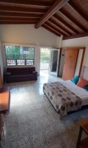 a bedroom with a bed and a couch and windows at CASA DE LOLA in Medellín