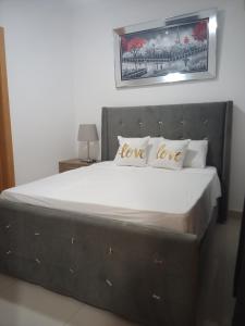 a bedroom with a large bed with a love love pillow at Simply the most comfortable place next to Boca Chica beach in Boca Chica