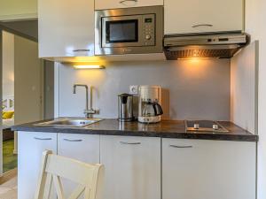 uma cozinha com um lavatório e um micro-ondas em Apartment Le Château de Kergonano-2 by Interhome em Baden