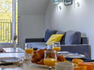 uma mesa com uma bandeja de pão e copos de sumo de laranja em Apartment Le Château de Kergonano-2 by Interhome em Baden