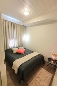Un dormitorio con una cama con una almohada roja. en Holiday Home Skivillas 47 ukkohalla - a1 by Interhome en Hyrynsalmi