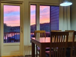 een eetkamer met een tafel en een balkon met een zonsondergang bij Holiday Home Skivillas 47 ukkohalla - a1 by Interhome in Hyrynsalmi