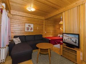 een woonkamer met een bank en een televisie bij Holiday Home Sotka 7 by bomba by Interhome in Nurmes