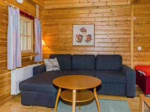 een woonkamer met een blauwe bank en een tafel bij Holiday Home Sotka 7 by bomba by Interhome in Nurmes