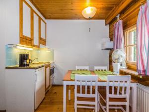 a kitchen with a table and chairs in a room at Holiday Home Sotka 7 by bomba by Interhome in Nurmes +7 photos