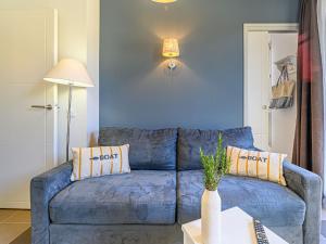 - un canapé bleu dans le salon avec une table dans l'établissement Apartment Le Château de Kergonano-1 by Interhome, à Baden