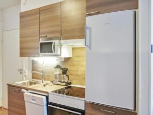 a kitchen with a white refrigerator and a sink at Holiday Home Skivillas 47 ukkohalla - a3 by Interhome in Hyrynsalmi