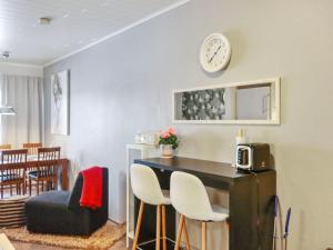 a living room with a table and a clock on the wall at Holiday Home Skivillas 47 ukkohalla - a3 by Interhome in Hyrynsalmi