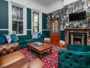 a living room with green furniture and a fireplace at Belvedere House in Cape Town