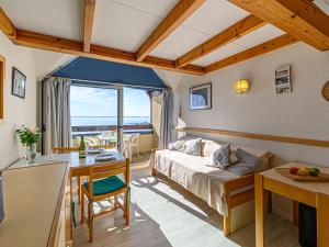 a hotel room with a bed and a desk and a kitchen at Apartment Plein Océan-2 by Interhome in Carnac