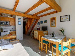 a living room with a dining table and a kitchen at Apartment Plein Océan-2 by Interhome in Carnac +14 photos