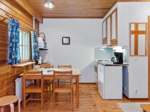 Una cocina y un comedor con mesa y sillas. en Holiday Home Sotka 13 by bomba by Interhome, en Nurmes