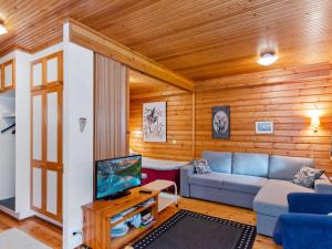 Una sala de estar con un sofá y un televisor. en Holiday Home Sotka 13 by bomba by Interhome, en Nurmes