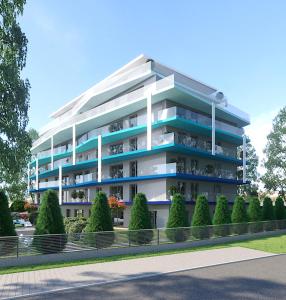 un gran edificio de apartamentos con árboles delante de él en HelloBalaton Apartman, en Balatonföldvár