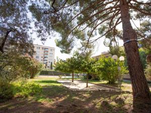 een park met bomen en een gebouw op de achtergrond bij Apartment Les Jardins du Luxembourg by Interhome in Hyères