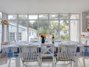 una sala da pranzo con tavolo, sedie e una finestra di Holiday Home Grande Ensouleihado by Interhome a Soulac-sur-Mer Altre 22 foto