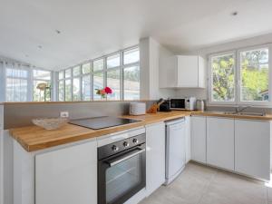 una cucina con mobili bianchi e un piano di lavoro in legno di Holiday Home Grande Ensouleihado by Interhome a Soulac-sur-Mer