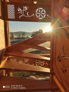 um conjunto de escadas com o sol brilhando através de uma janela em Rusiński Wypas Bukowina Tatrzańska - apartament i dwa domki z pięknymi widokami, zewnętrzną sauną i przestronnym parkingiem w cenie em Bukowina Tatrzańska