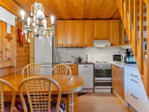 La cuisine est équipée d'une table, de chaises et d'un réfrigérateur. dans l'établissement Holiday Home Vuonelo 8 a 2 by Interhome, à Saariselka