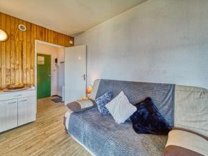 een slaapkamer met een bed met blauwe en witte kussens bij Apartment Baikonour-8 by Interhome in Le Corbier