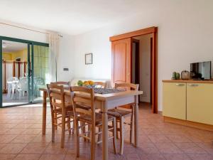 eine Küche und ein Esszimmer mit einem Tisch und Stühlen in der Unterkunft Apartment L'Oasi Trilo A6 by Interhome in Trinità dʼAgultu