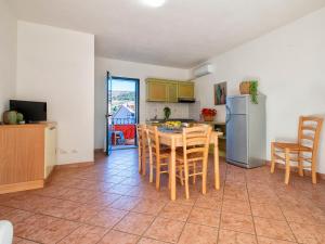 cocina con mesa, sillas y nevera en Apartment L'Oasi Trilo A6 by Interhome, en Trinità dʼAgultu