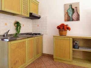 una cocina con armarios de madera y fregadero en Apartment L'Oasi Trilo A6 by Interhome, en Trinità dʼAgultu