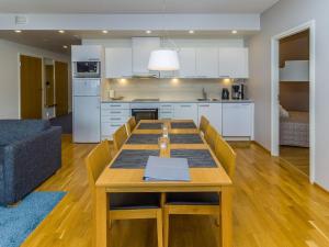 eine Küche und ein Wohnzimmer mit einem Holztisch und Stühlen in der Unterkunft Holiday Home Lumi-chalet 1312 by Interhome in Ruka + 14 Fotos