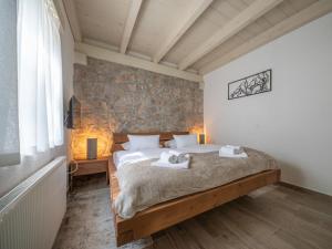 een slaapkamer met een bed en een stenen muur bij Chalet Didova suma 2 by Interhome in Alan