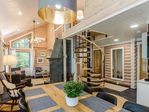 a dining room with a table and a spiral staircase at Holiday Home Villa usva by Interhome in Kolinkylä