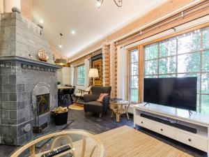a living room with a large television and a fireplace at Holiday Home Villa usva by Interhome in Kolinkylä