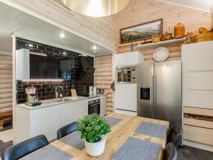 a kitchen with a table and a refrigerator at Holiday Home Villa usva by Interhome in Kolinkylä +25 photos