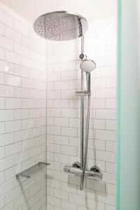 La salle de bains est pourvue d'une douche avec du carrelage blanc. dans l'établissement pentahotel Liège, à Liège